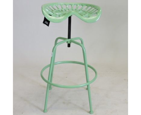 A green painted metal tractor seat stool