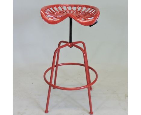 A red painted metal tractor seat stool