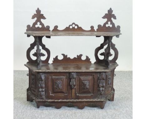 A 19th century heavily carved dark oak hanging shelf, 61cm, together with a 1920's carved oak cabinet