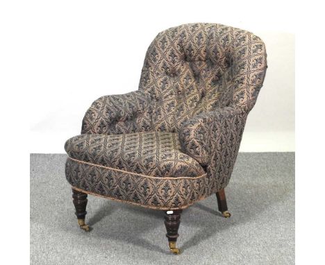 A Victorian upholstered armchair, with a button back, on turned legs