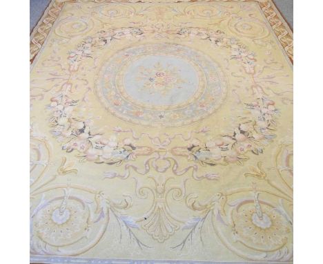A tapestry rug, with a central medallion and scrolled design, on a yellow ground, 305 x 243cm