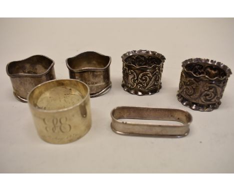 A pair of Edwardian silver embossed napkin rings, by J &amp; R Griffin, Chester 1902; together with four other examples, 188g