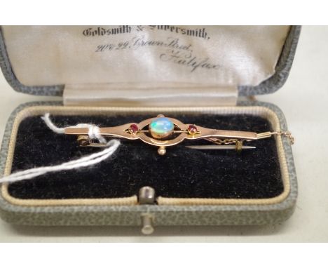 A cabochon opal and ruby gold bar brooch, hallmarks indistinct, 2.6g total weight. 