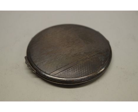 An engine turned white metal powder compact, inscribed 'Silver', 8.5cm diameter. 