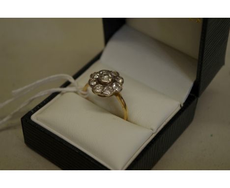 A diamond 'daisy' cluster gold ring, stamped 18ct, 3.6g total weight. 