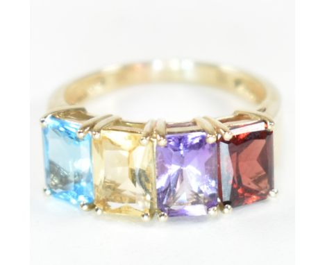 A hallmarked 9ct gold, garnet, amethyst, citrine and topaz ring. The ring set with a row of emerald cut garnet, amethyst, cit