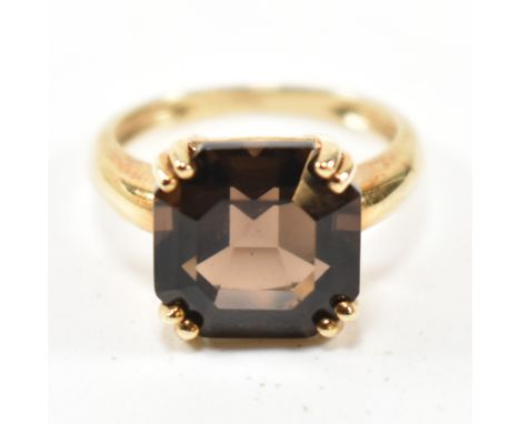 A hallmarked 9ct gold and smoky quartz ring. The ring set with a single double claw set smoky quartz to tapered shank. Hallma
