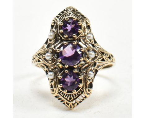 A 9ct gold, amethyst and pearl ring. The Art Nouveau style ring having a pierced panel head set with three round mixed cut am