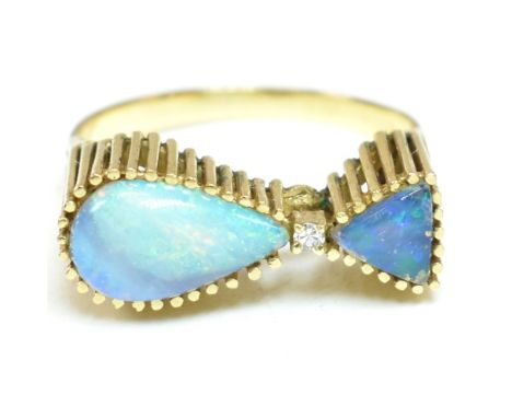 A retro opal and diamond ring. The ring set with a tear drop opal and a triangular shaped opal doublet / triplet with central