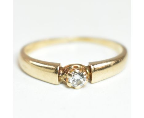 A gold and diamond solitaire ring. The ring having a central round brilliant cut diamond set in a decorative mount to tapered