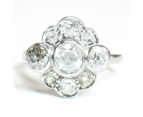 An 18ct white gold and diamond cluster ring. The ring set with three central old cut diamonds surrounded by six old cut diamo