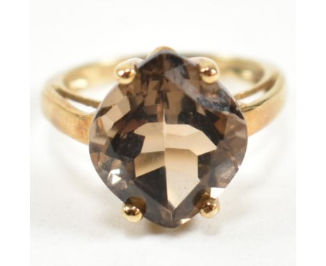 A hallmarked 9ct gold and smoky quartz ring. The ring having a single four claw set wide marquise cut smoky quartz set in a b