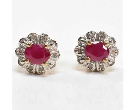 A pair of 9ct gold, ruby and diamond cluster stud earrings. The 9ct gold stud earrings having a central four claw set oval cu