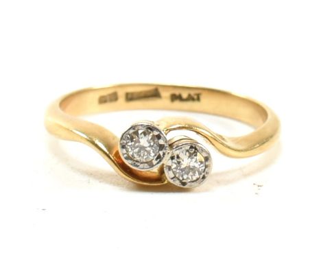 A cased 18ct gold platinum and diamond two stone ring. The ring set with two brilliant cut diamonds to a bypass mount. Marked