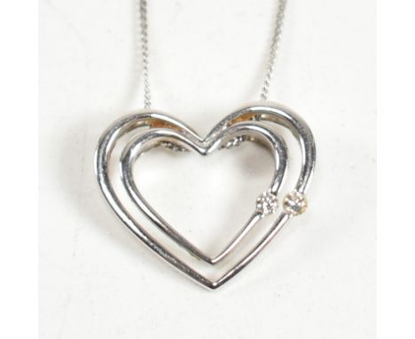 A 9ct white gold and white stone? heart pendant necklace. The fine curb link chain necklace strung with a heart pendant set w