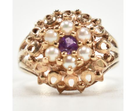 A 1970s hallmarked 9ct gold, pearl and amethyst dome ring. The ring having a central round cut amethyst surrounded by a halo 