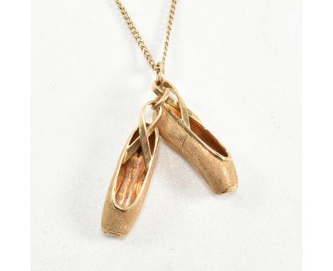 A 14ct gold ballet shoes pendant necklace. The 14ct gold curb link chain necklace strung with a pendant in the form of a pair