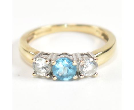A hallmarked 9ct gold, CZ and topaz three stone ring. The ring having a central four claw set round cut topaz flanked by two 