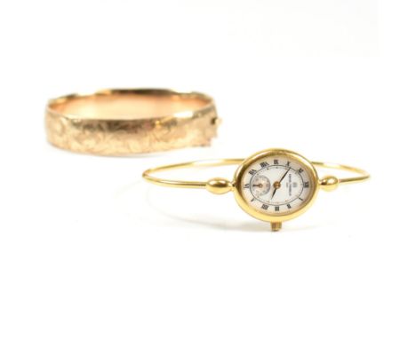 A 9ct gold metal core hinged bangle and a gold tone metal bangle watch. The lot to include a 9ct gold metal core engraved hin
