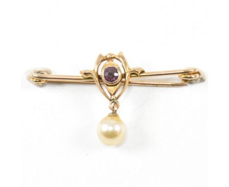A hallmarked Edwardian Art Nouveau 9ct gold amethyst brooch pin. The brooch strung with a simulated pearl surmounted by bezel