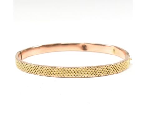 A vintage hallmarked 9ct gold hinged bangle. The bangle having a textured pineapple decoration to head to plain back with con