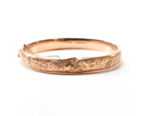 An early 20th century hallmarked 9ct rose gold engraved hinged bangle.&nbsp;The 9ct rose gold bangle having engraved scrollin