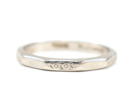 A platinum faceted band ring. The ring having an etched design to every other facet, with the others being plain. Marked PLAT