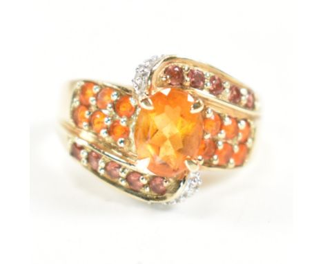A hallmarked 9ct gold&nbsp; diamond and gem set crossover ring. The ring having a central oval cut citrine set in a crossover