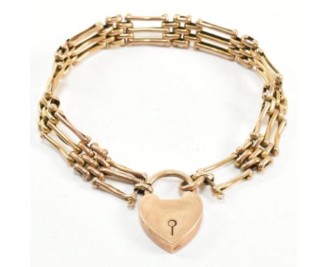An Edwardian hallmarked 9ct gold gate link bracelet with a heart padlock clasp. The 9ct gold gate link bracelet having a 9ct 