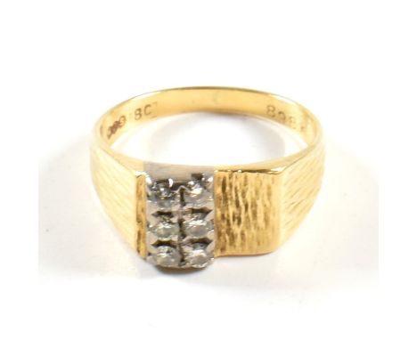 An 18ct gold and diamond ring. The ring set with two rows of three round brilliant cut diamonds to bark effect shoulders to p