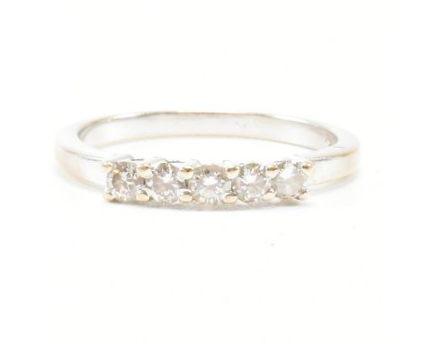 An 18ct white gold and diamond five stone ring. The ring set with five round brilliant cut diamonds to pain shank. Stamped 75