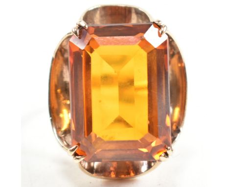 A 1970s hallmarked 9ct gold and synthetic spinel cocktail ring. The ring having a single double claw set emerald cut syntheti