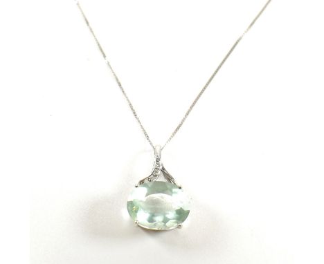 A hallmarked 9ct white gold, diamond and green stone pendant necklace. The pendant set with an oval cut green stone surmounte