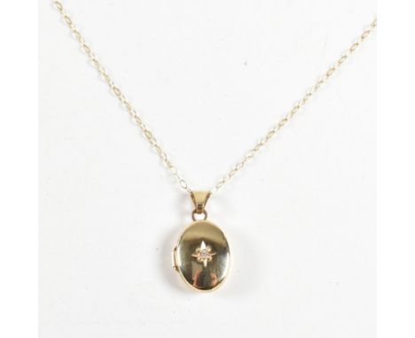 A 9ct gold and white stone locket pendant necklace. The 9ct gold chain necklace strung with an oval locket pendant set with a