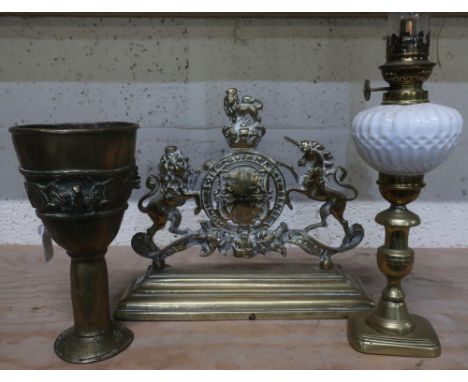 Reproduction brass Royal Warrant, a 19th C paraffin lamp with opaque glass shade and an Eastern brass goblet (3) 