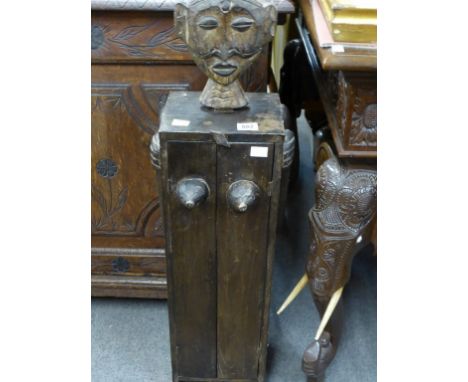 A small tribal carved book shelf with interesting anatomical form.