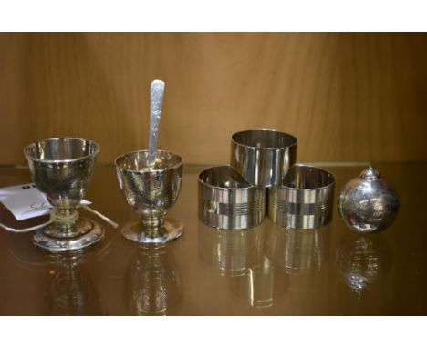 A small collection of silver items, European and Asian to include two egg cups, three napkin rings, a small spoon and a round