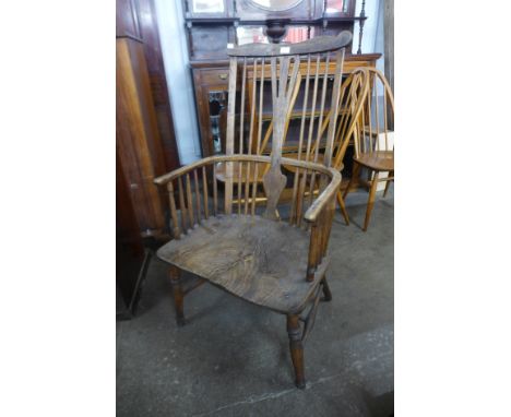 A primitive 19th Century elm and beech comb back Windsor armchair 