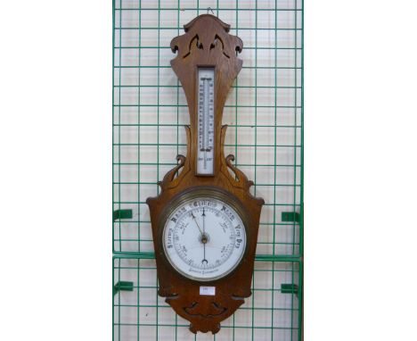 An early 20th Century carved oak aneroid barometer 