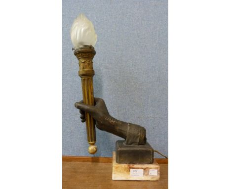 A French Art Deco style table lamp in the form of a hand holding a torch 