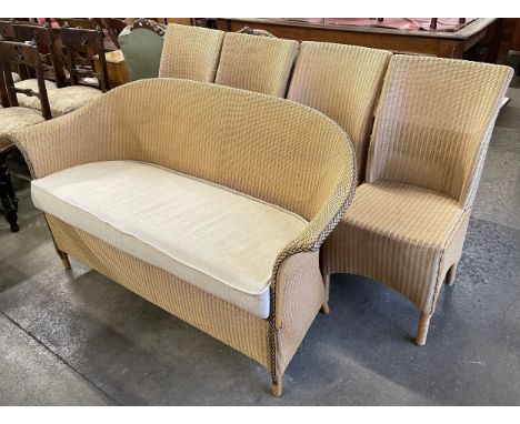 A Lloyd Loom wicker conservatory suite comprising; four chairs, a settee and a large wall hanging mirror