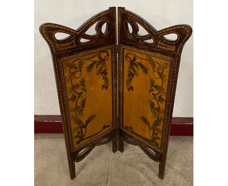 An Art Nouveau beech and penwork folding fire screen 