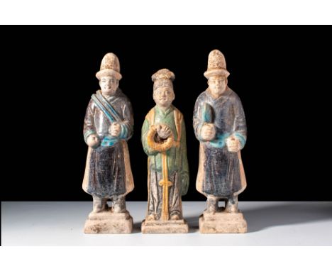 Ming Dynasty, Ca. AD 1368-1644.
A group of three terracotta figures. They appear to be attendants, dressed in aubergine-glaze