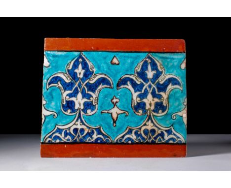 Ca. 16th century AD. A border tile of rectangular form decorated on a turquoise ground with two central palmettes tapering to