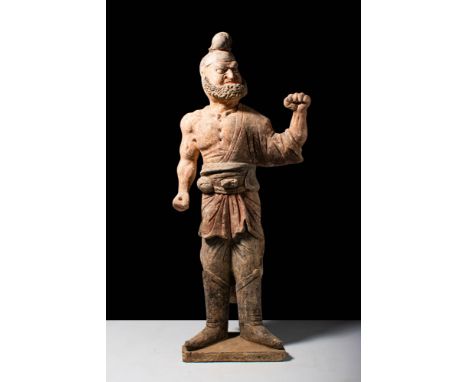 Tang Dynasty, Ca. AD 618-907.
A terracotta foreigner figure. The figure is depicted in a dynamic pose, standing on a shallow 