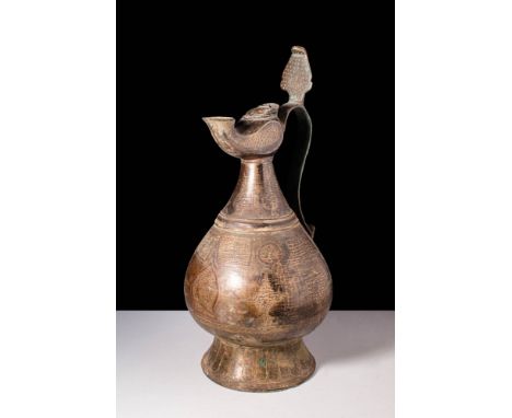 Ca. 8th - 9th century AD.
A bronze ewer decorated with decorative cartouches on its pear-shaped body. The jug tapers into a n