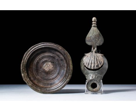 .A bronze oil lamp and bowl, the oil lamp stylised with a leaf shaped thumb-rest and lid in the form of a shell. Size: 170mm 