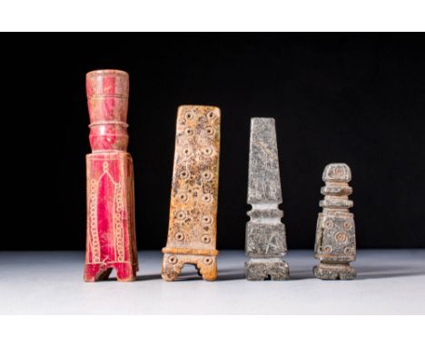 .A group of four, including two bone kohl bottles. One is stained red with incised decoration showing columns or niches on th