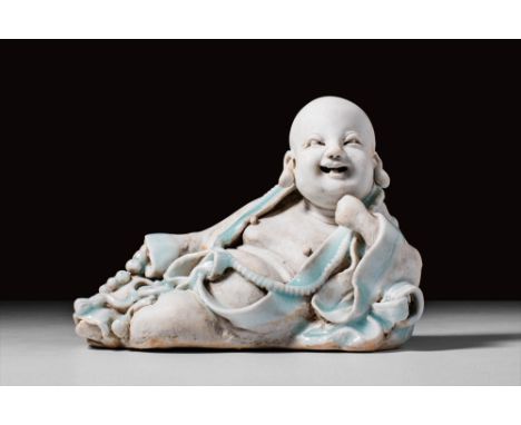 Southern period, Song Dynasty, Ca. AD 960-1279.
A Qingbai porcelain figure of Budai, the Laughing Buddha. Reclined on his lef