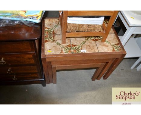 A nest of three teak tile top coffee tables 